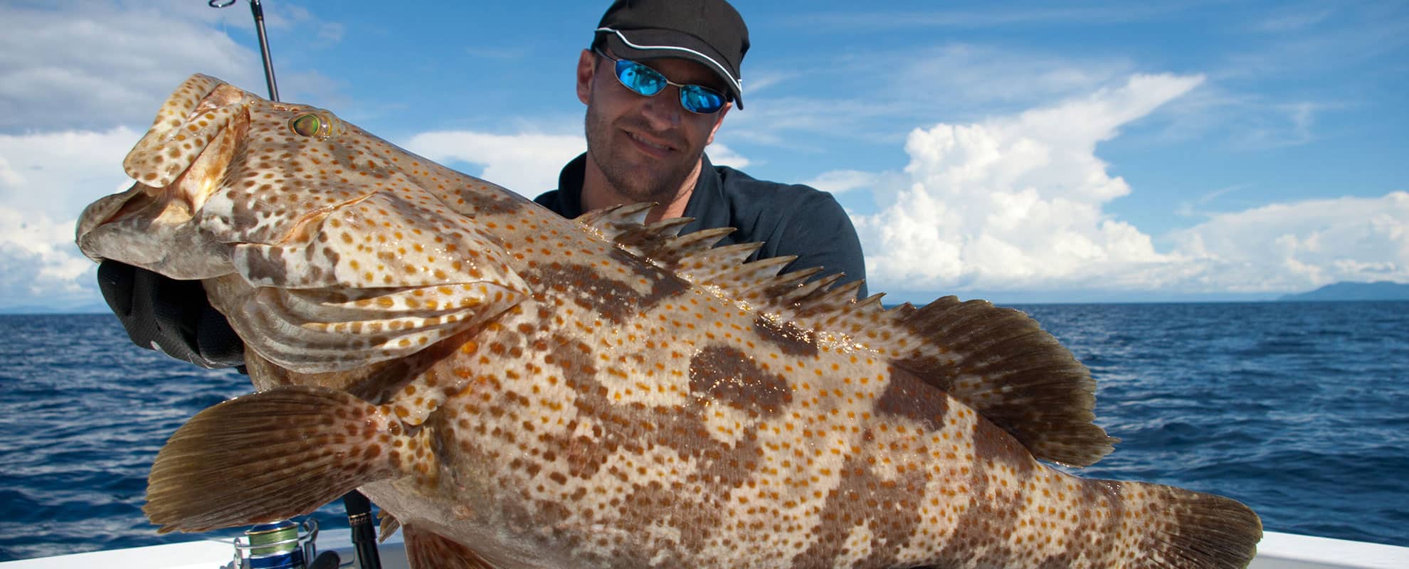 Sportfiskare med grouper - kusdfiske i Spanien med spanskt fiskekort